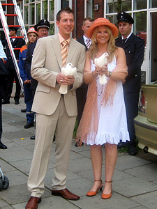 Das Hochzeitspaar Olli und Nadine vor dem Standesamt mit wei�en Tauben in den H�nden.