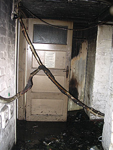 Ruß ist an den Kellerwänden zu sehen und Elektrokabel hängen von der Decke gefährlich herunter.